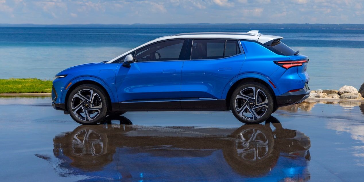 Vue de profil du Chevrolet Equinox EV 2026 bleu au bord de l’eau.