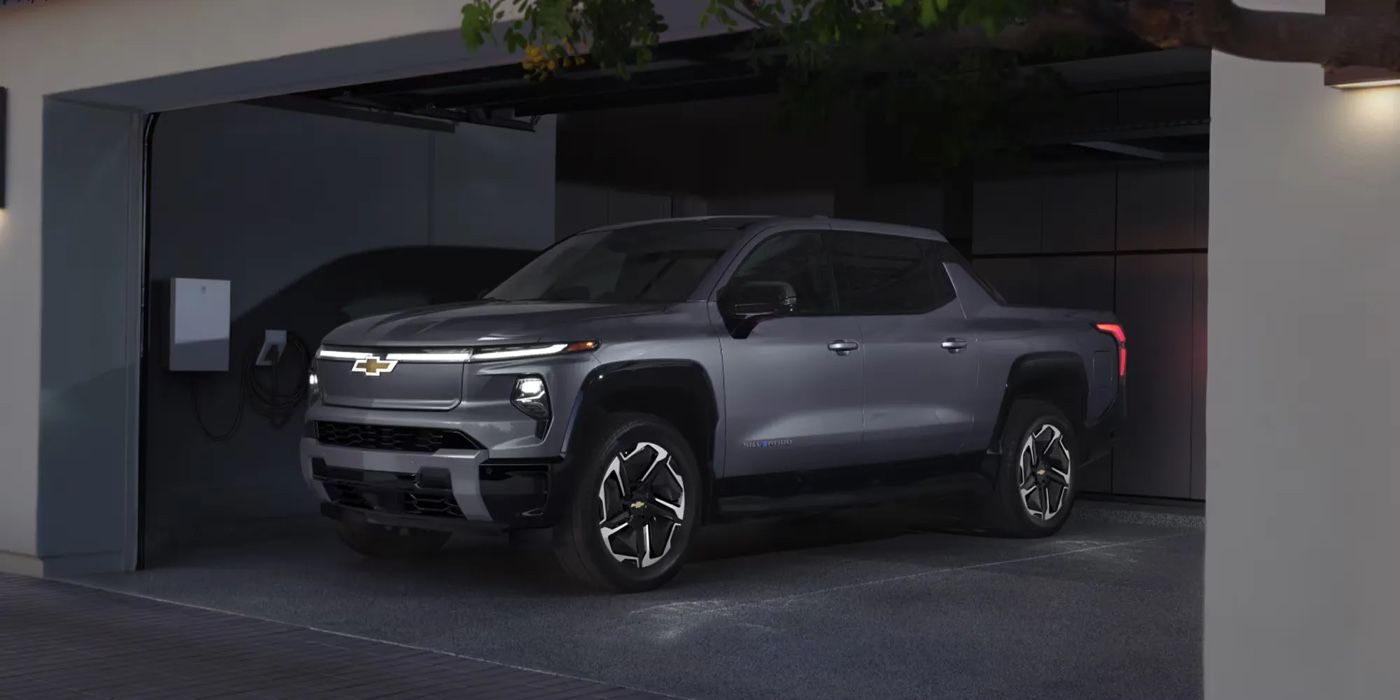Chevrolet Silverado EV 2026 gris stationné dans un garage connecté à une borne de recharge électrique.
