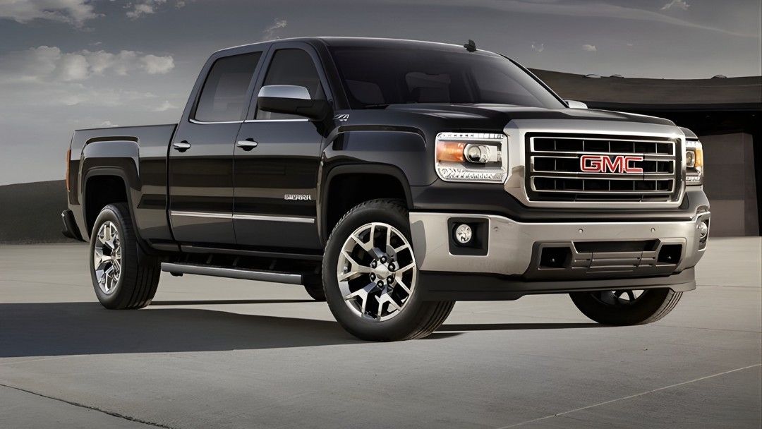 GMC Sierra 1500 Denali 2014 noir stationné sur une surface bétonnée, illustrant la gamme haut de gamme des pickups GMC.